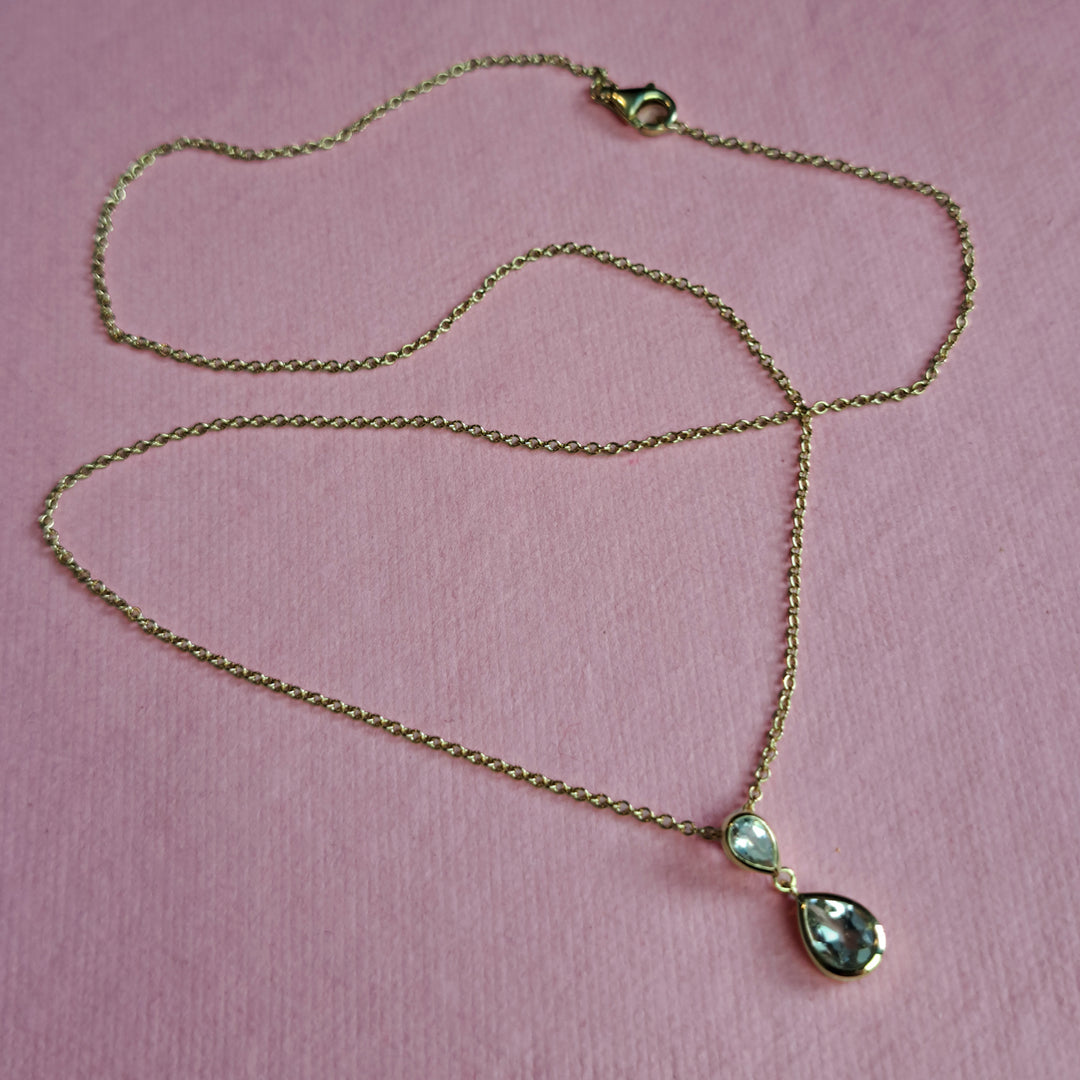 14ct gold two stone drop pendant necklace in green amethyst on a pink background