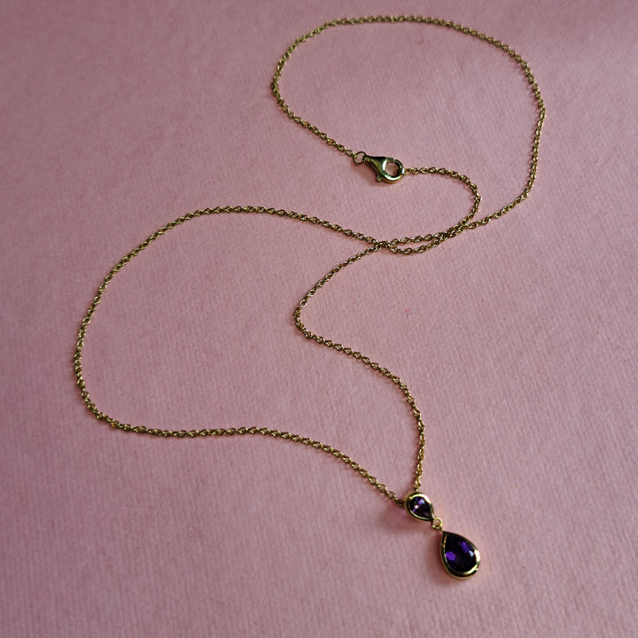 14ct gold two stone drop pendant necklace in amethyst on a pink background
