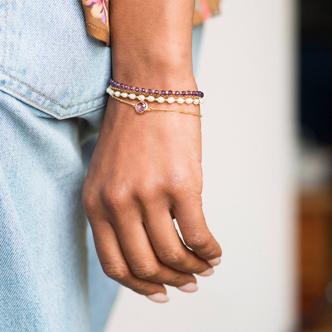 Gold, amethyst and Pearl Beaded Bracelets on a woman's wrist.