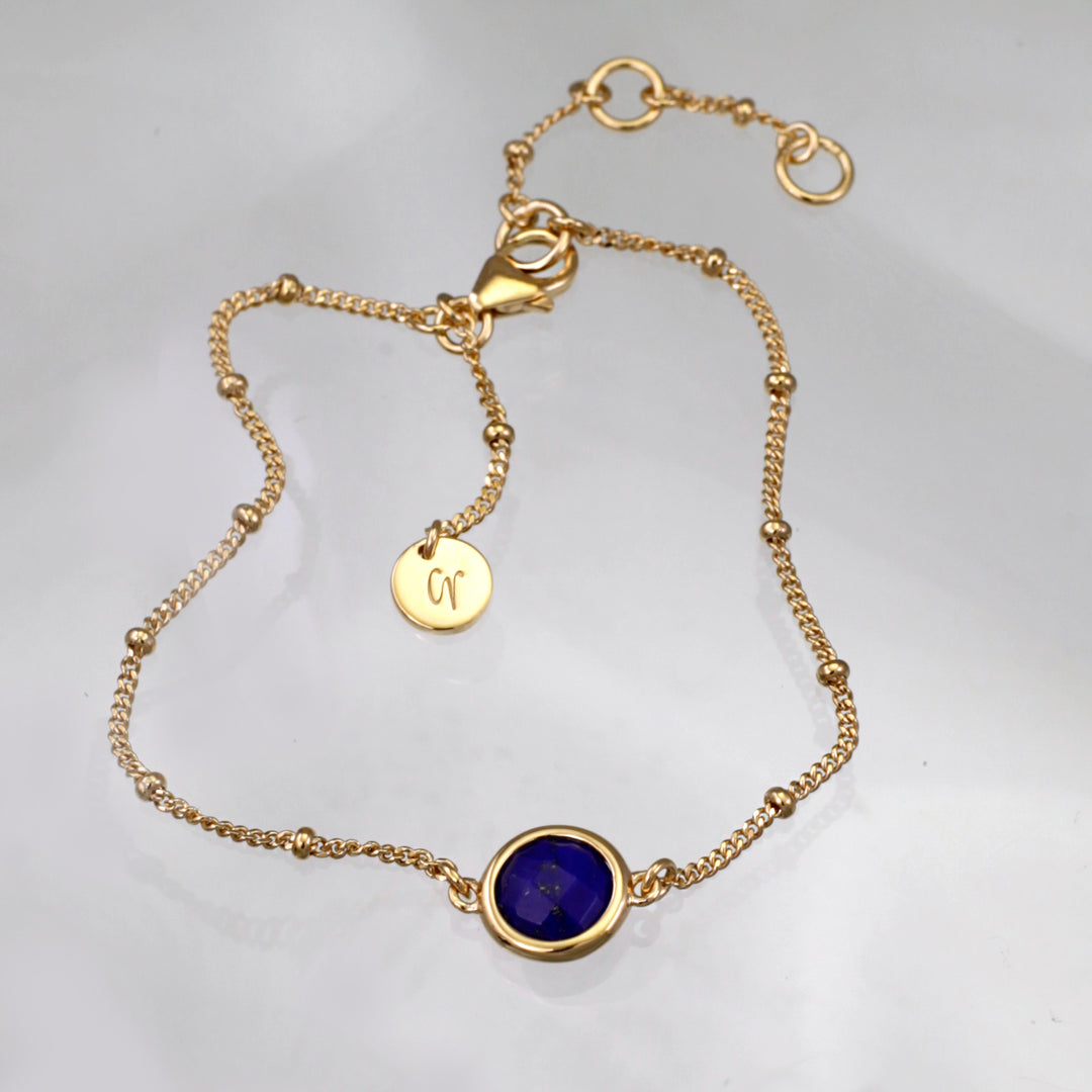 Gold vermeil beaded chain bracelet with lapis lazuli on a reflective background