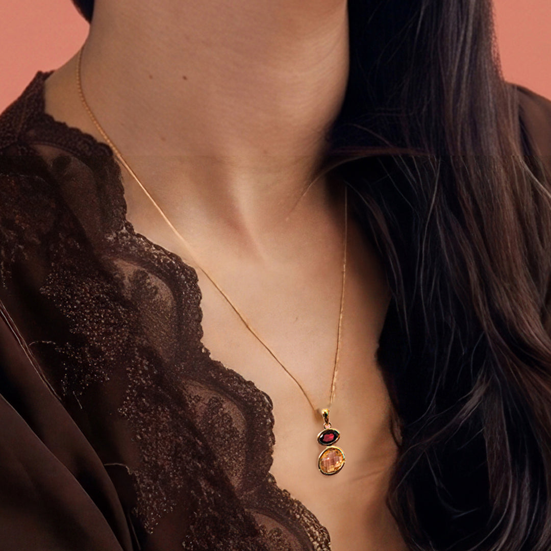 Close-up of woman wearing an 18ct gold vermeil pendant necklace with citrine & garnet