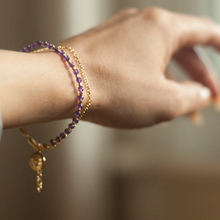 Woman wearing a gold vermeil beaded compass bracelet with amethyst