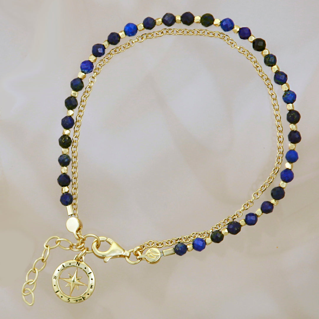 Gold vermeil beaded compass bracelet in lapis lazuli on a reflective background