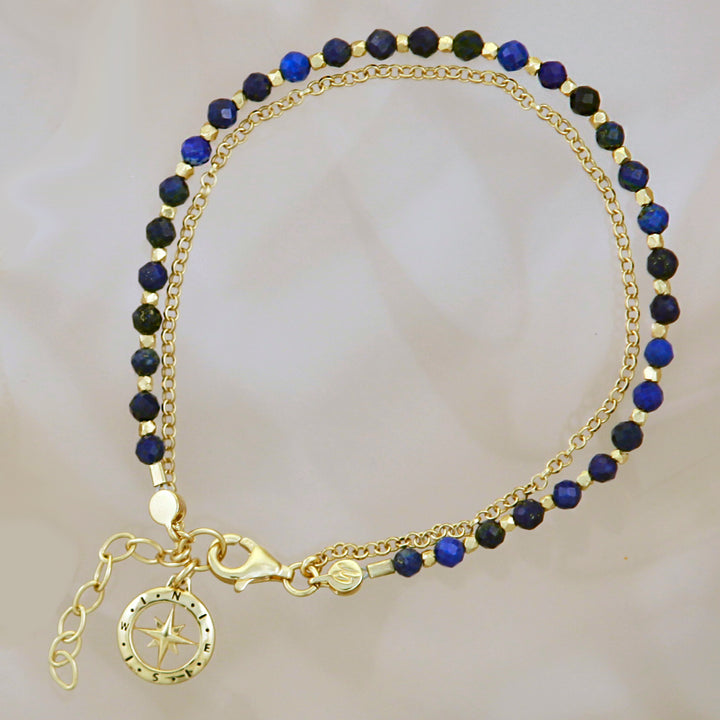 Gold vermeil beaded compass bracelet in lapis lazuli on a reflective background