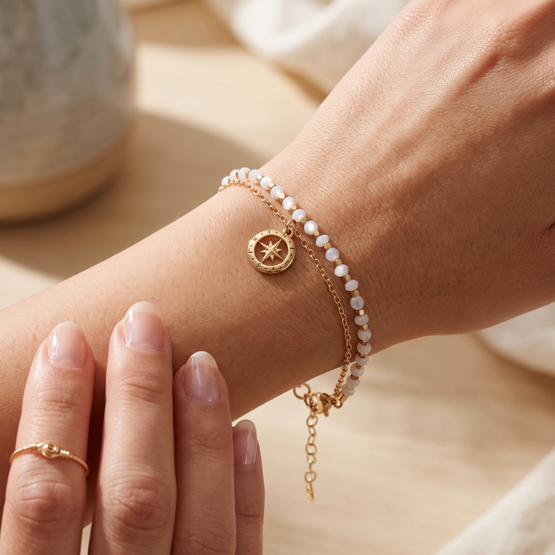 Close-up of woman wearing an 18ct gold vermeil beaded compass bracelet in moonstone