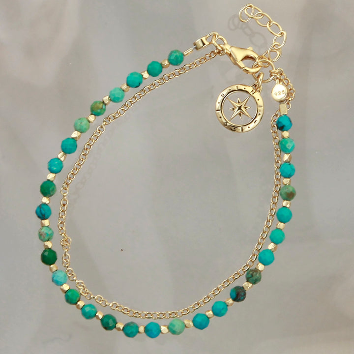 Gold vermeil compass beaded bracelet in turquoise on a reflective background