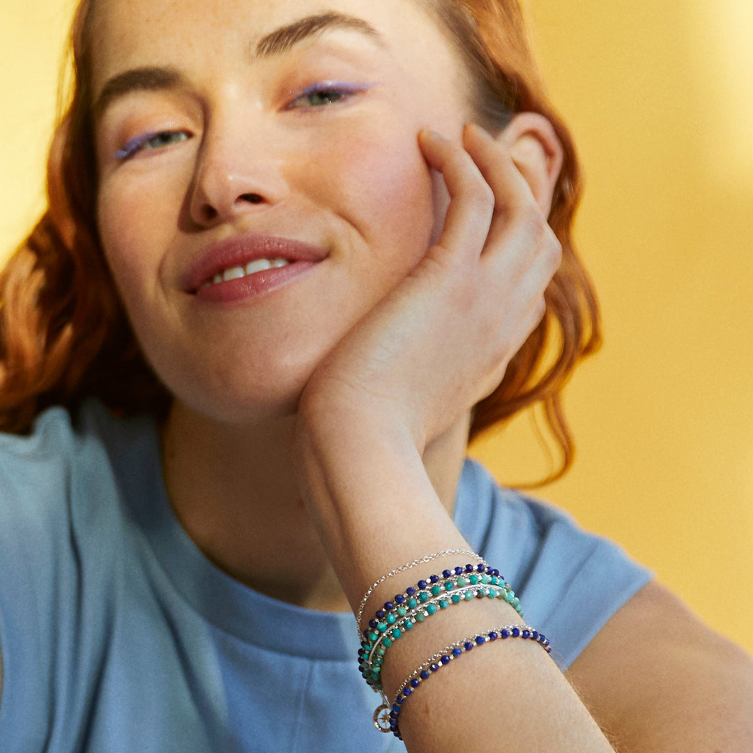 Woman wearing gold vermeil compass beaded bracelets in turquoise