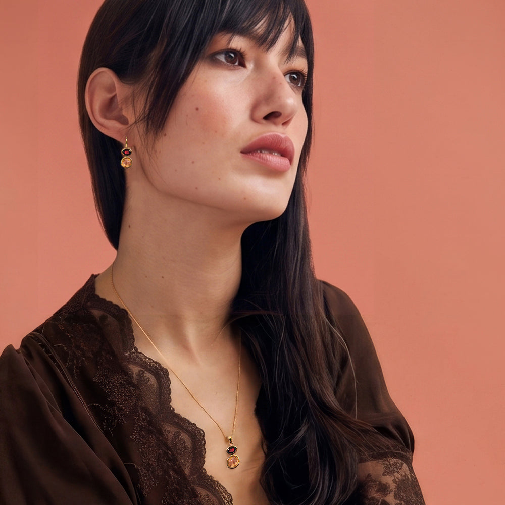 Woman wearing 18ct gold vermeil drop earring and necklace set with citrine & garnet