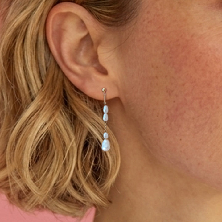 Close-up of woman wearing gold vermeil freshwater pearl drop  studs