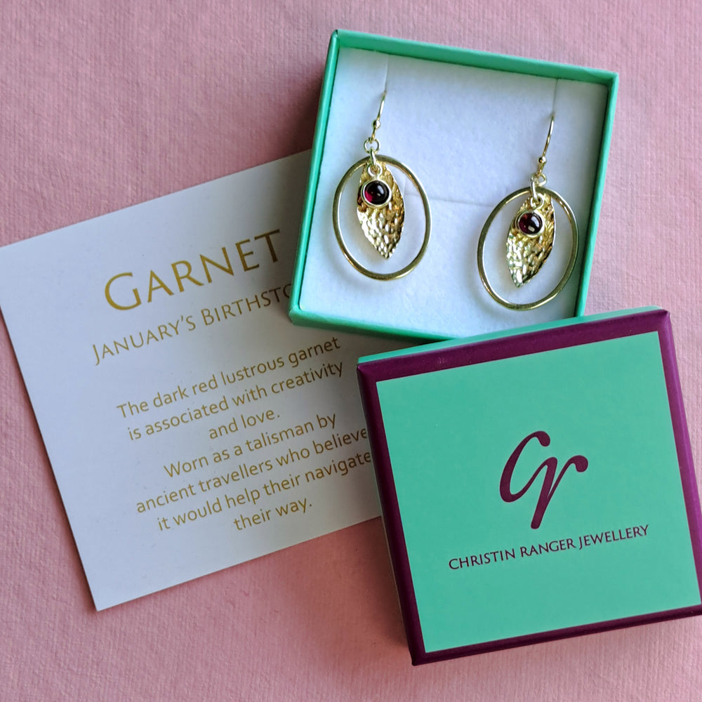 Gold vermeil drop earrings with oval hoops set with garnet cabachon gemstones
in Christin Ranger Jewellery gift packaging