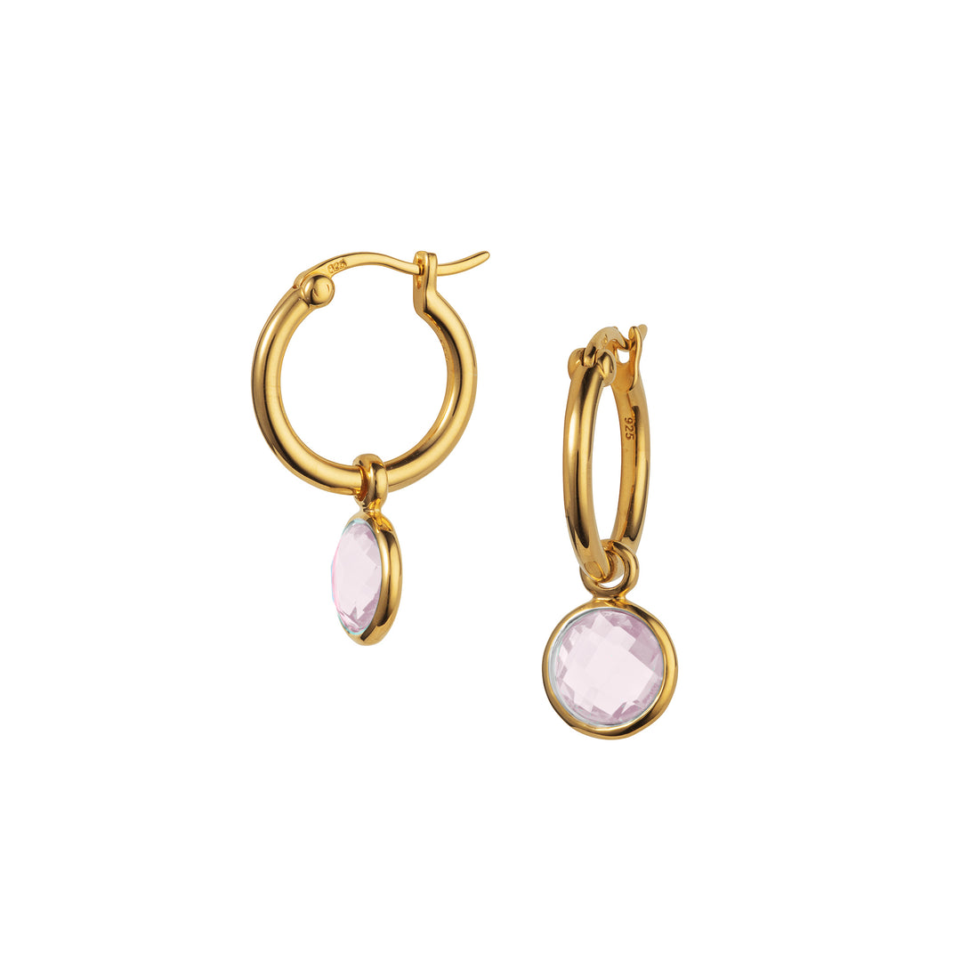 Gold hoop earrings with pink gemstones on a white background