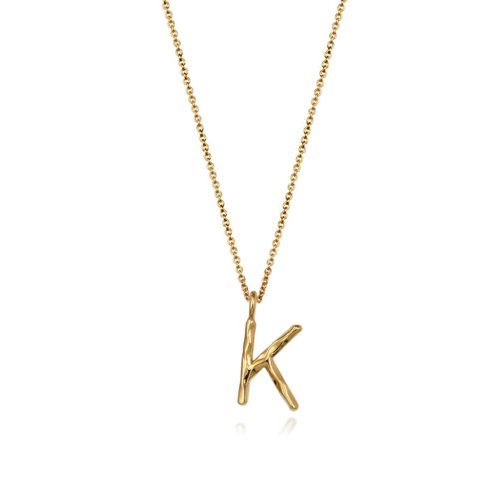 Gold vermeil letter K initial necklace pendant with chain on a white background.