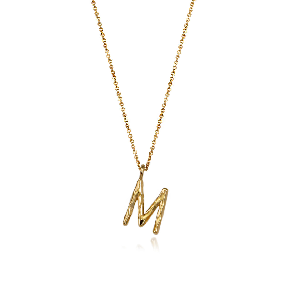 Gold vermeil letter M initial necklace pendant with chain on a white background.