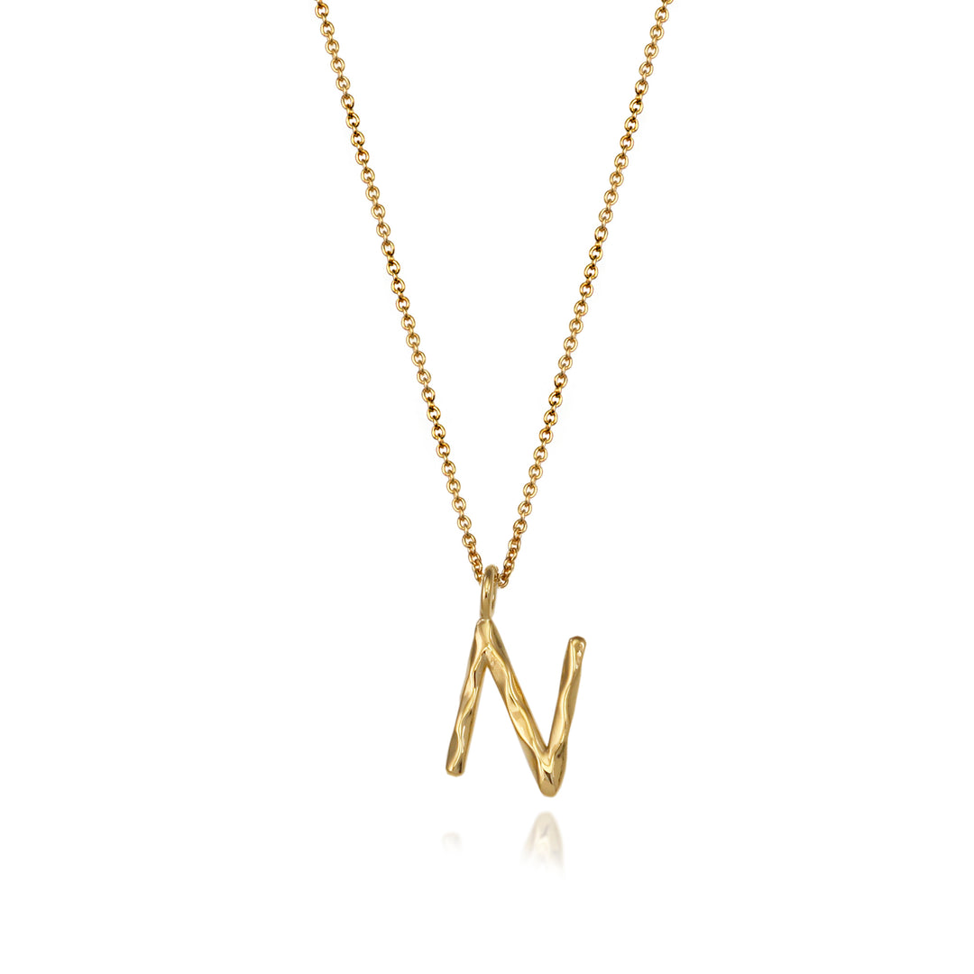 Gold vermeil letter N initial necklace pendant with chain on a white background.