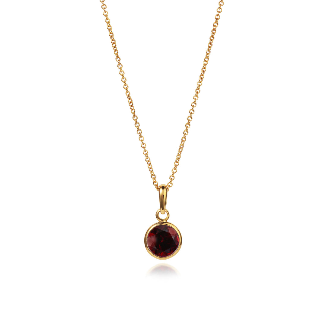 Gold vermeil necklace and chain with garnet gemstone on a white background