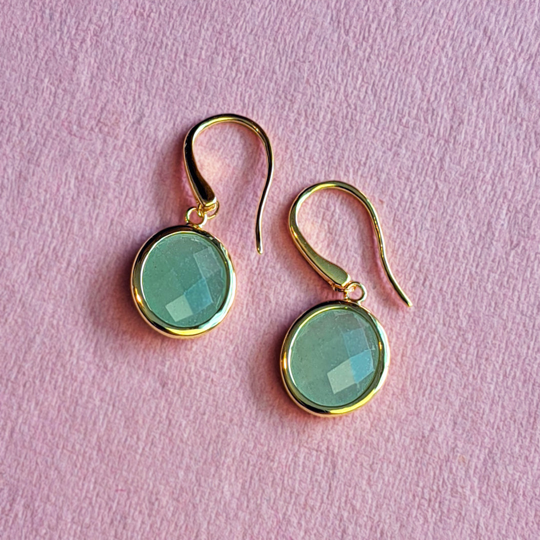 18ct gold vermeil oval drop earrings with jade-green aventurine gemstones on a pink background