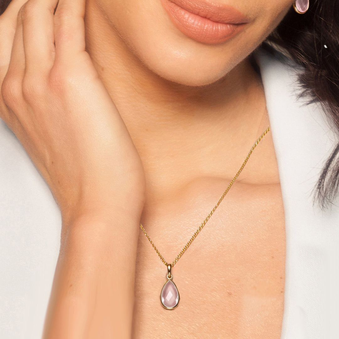 Close-up of woman wearing a gold vermeil pear drop pendant necklace with rose quartz