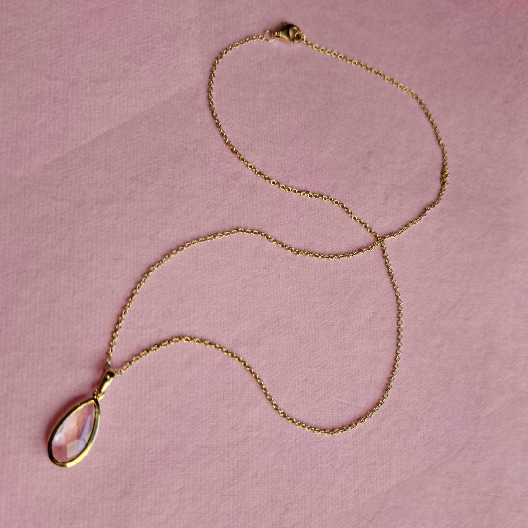 Gold vermeil pear drop pendant necklace with rose quartz on a pink background