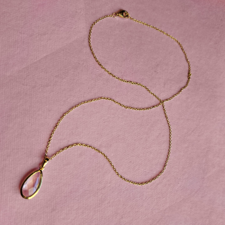 Gold vermeil pear drop pendant necklace with rose quartz on a pink background