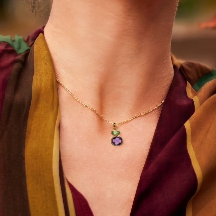 Close-up of woman wearing 18ct gold vermeil pendant necklace with amethyst & peridot gemstones