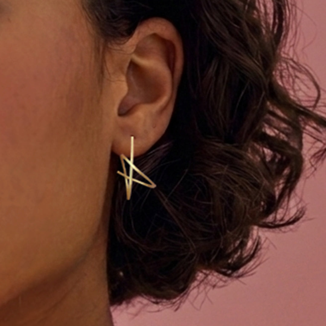 Close-up of woman wearing gold vermeil spiral stud earrings