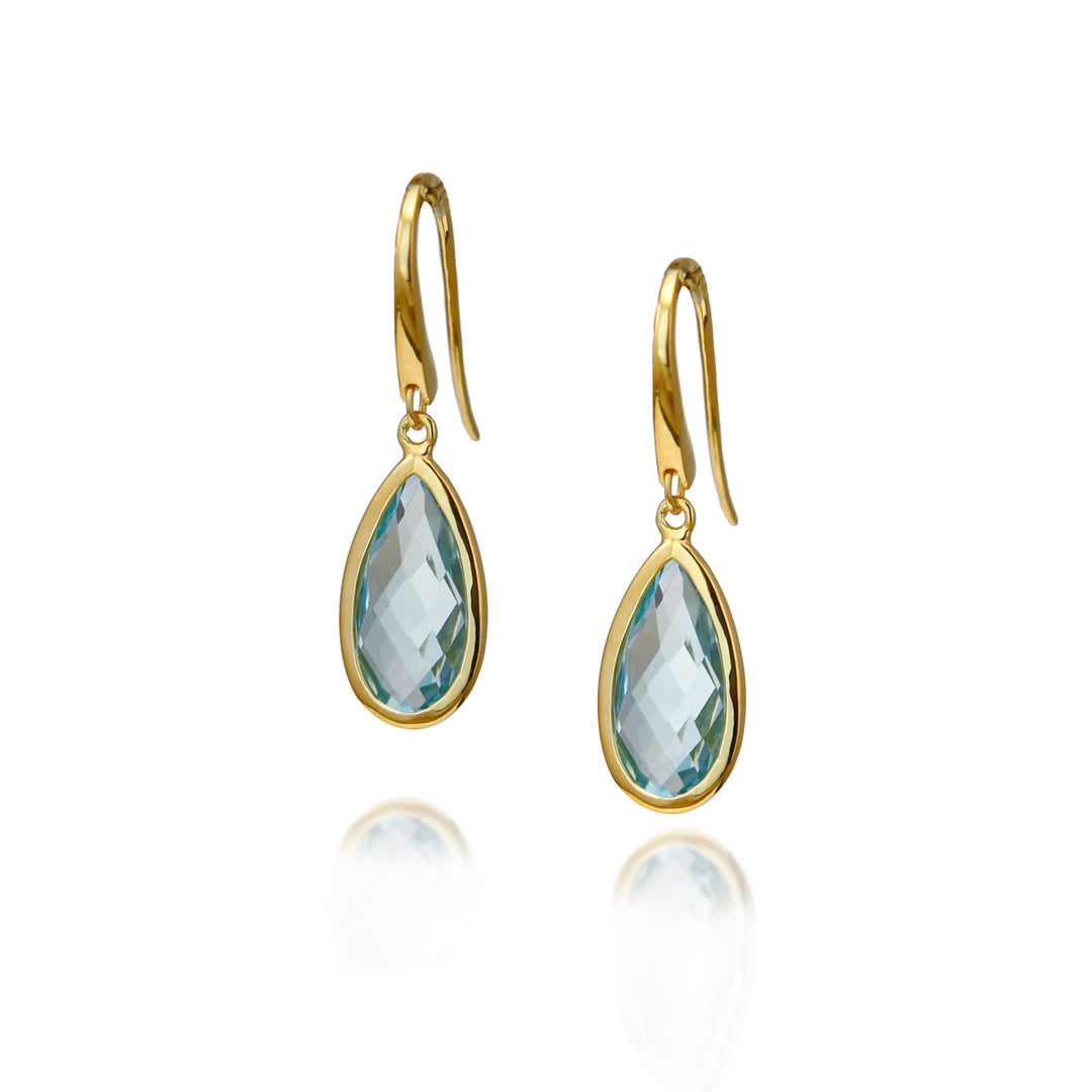 Gold teardrop shaped blue topaz gemstone earrings on a white background