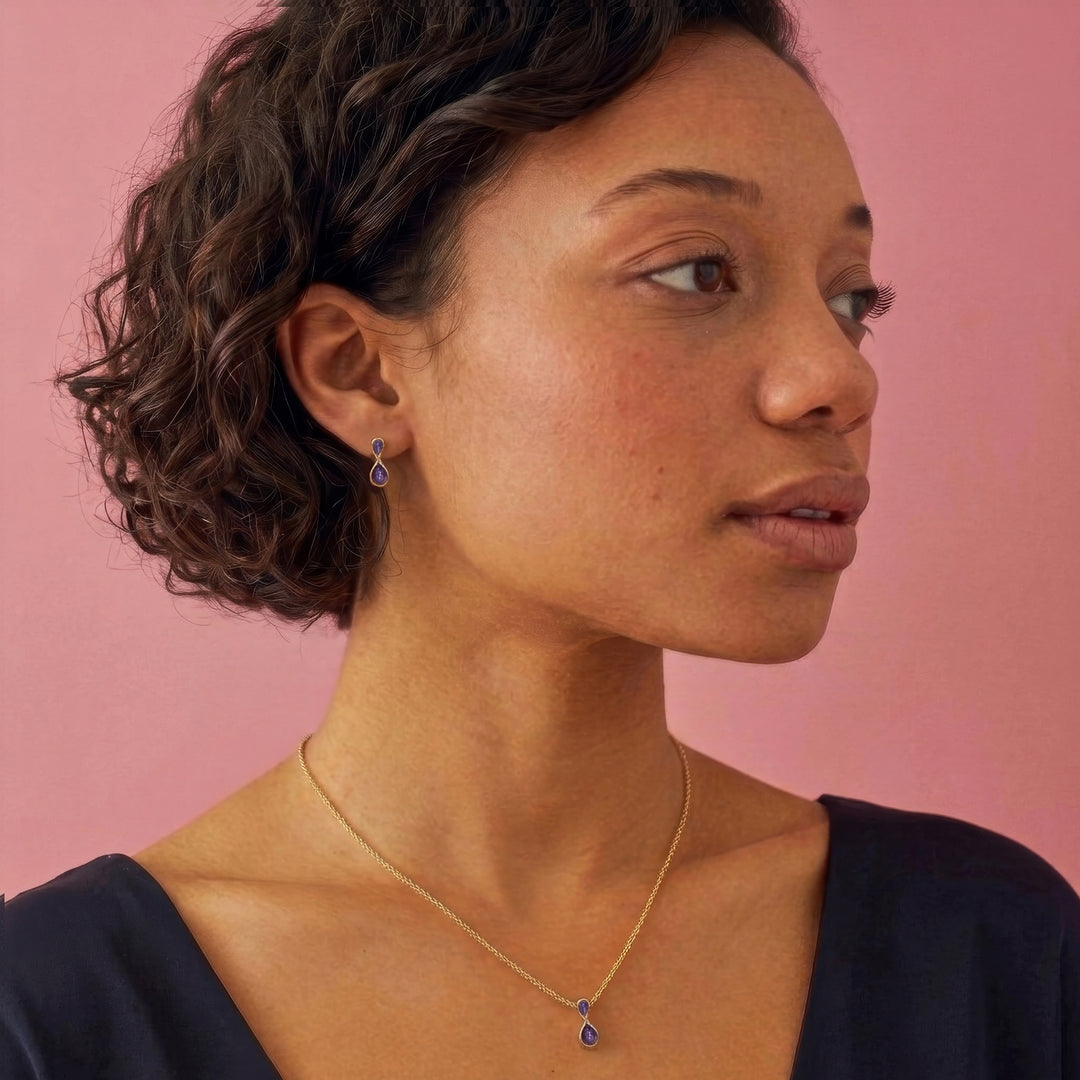Woman  wearing a 14ct gold vermeil two stone drop earring and necklace set with amethyst gemstones
