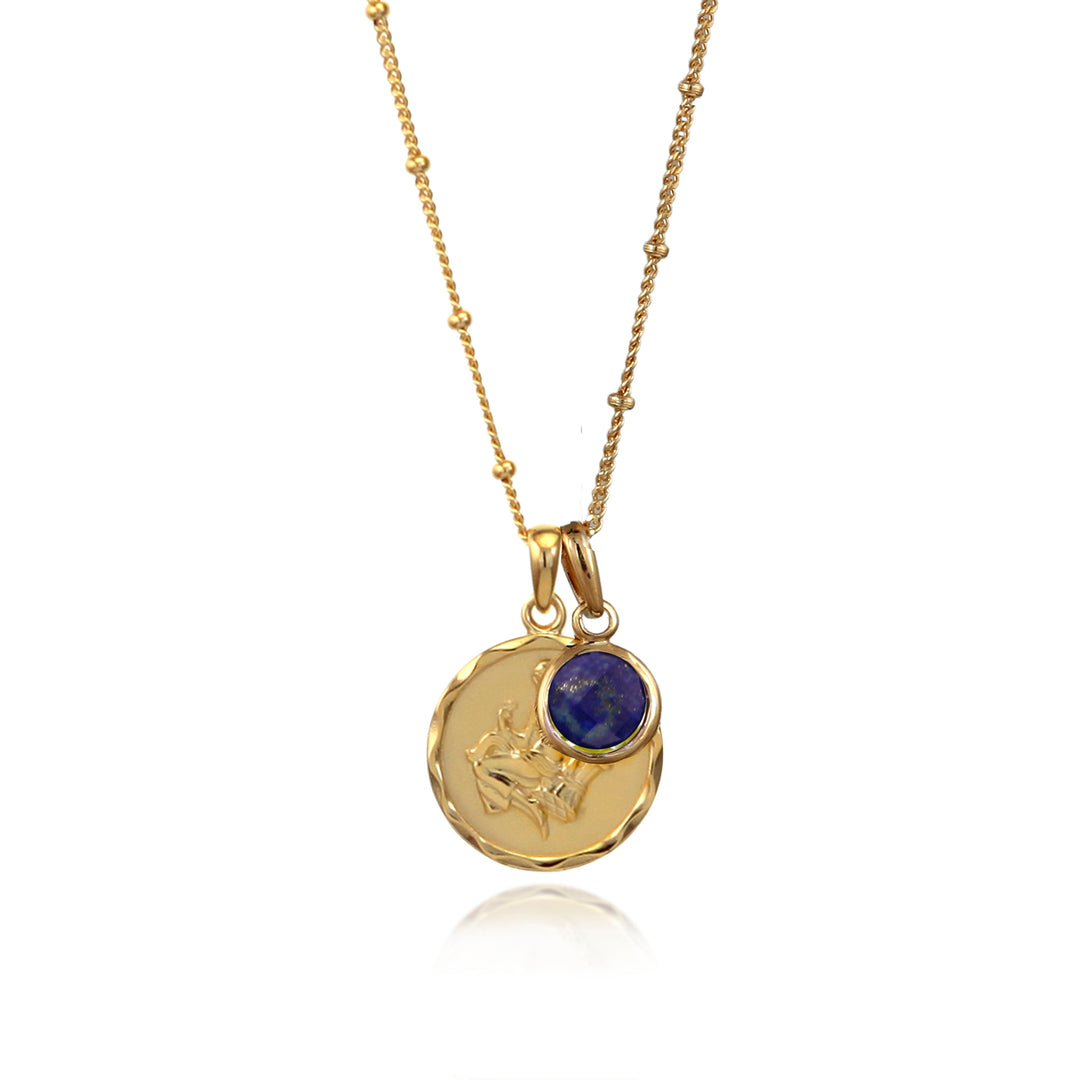 Gold Virgo zodiac pendant and blue lapis September birthstone charm on a white background