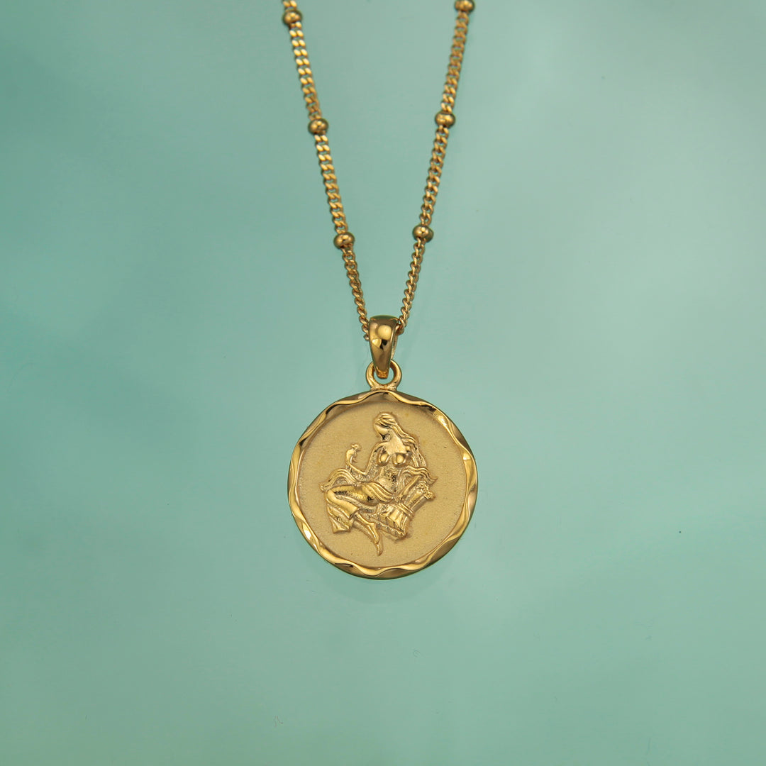 18ct gold vermeil Taurus zodiac star sign pendant necklace on a teal background