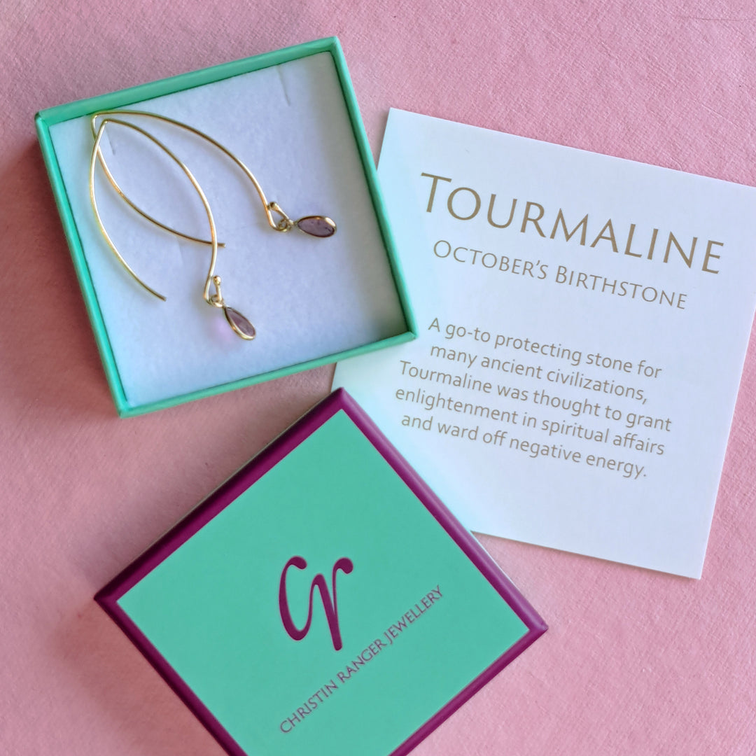 Gold hook earrings with pink teardrop shaped pink tourmaline gemstones in Christin Ranger Jewellery gift packaging.