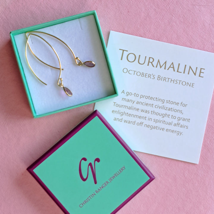 Gold hook earrings with pink teardrop shaped pink tourmaline gemstones in Christin Ranger Jewellery gift packaging.