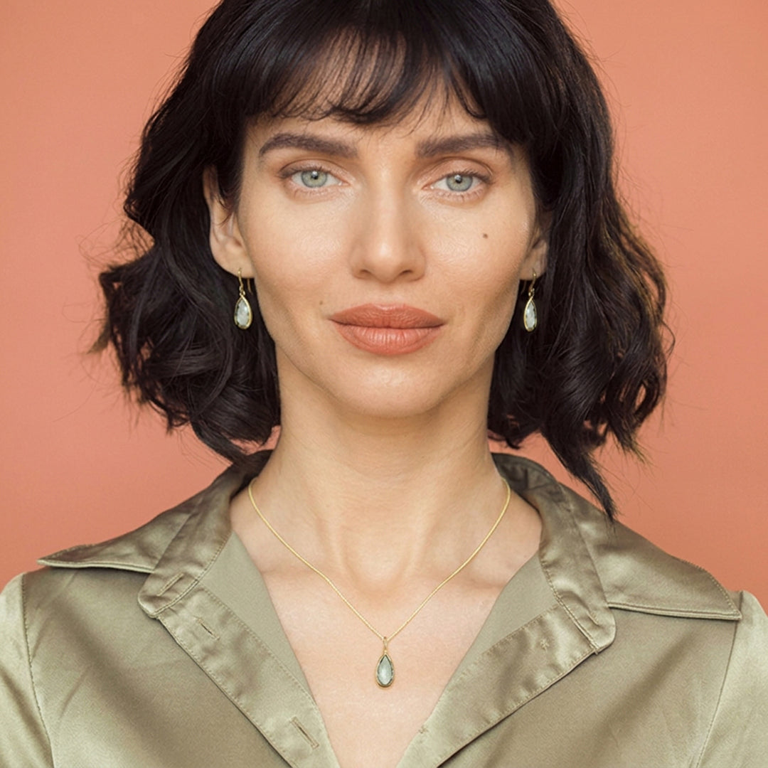 Woman wearing green amethyst pear drop earring and necklace set in 18ct gold vermeil