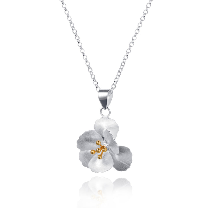 Silver and gold necklace with a floral pendant on a white background