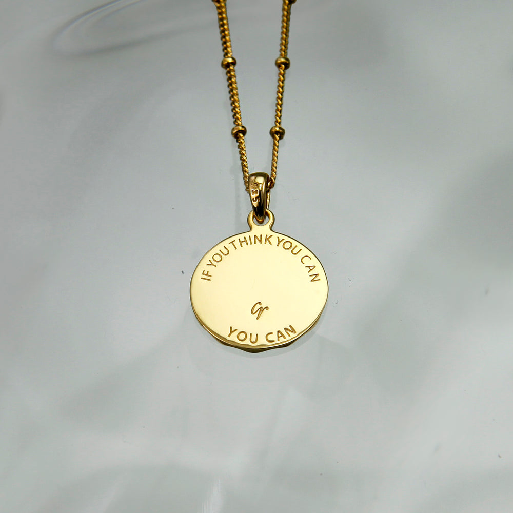 Reverse silver of a lucky charm horseshoe pendant with an engraved message on the back