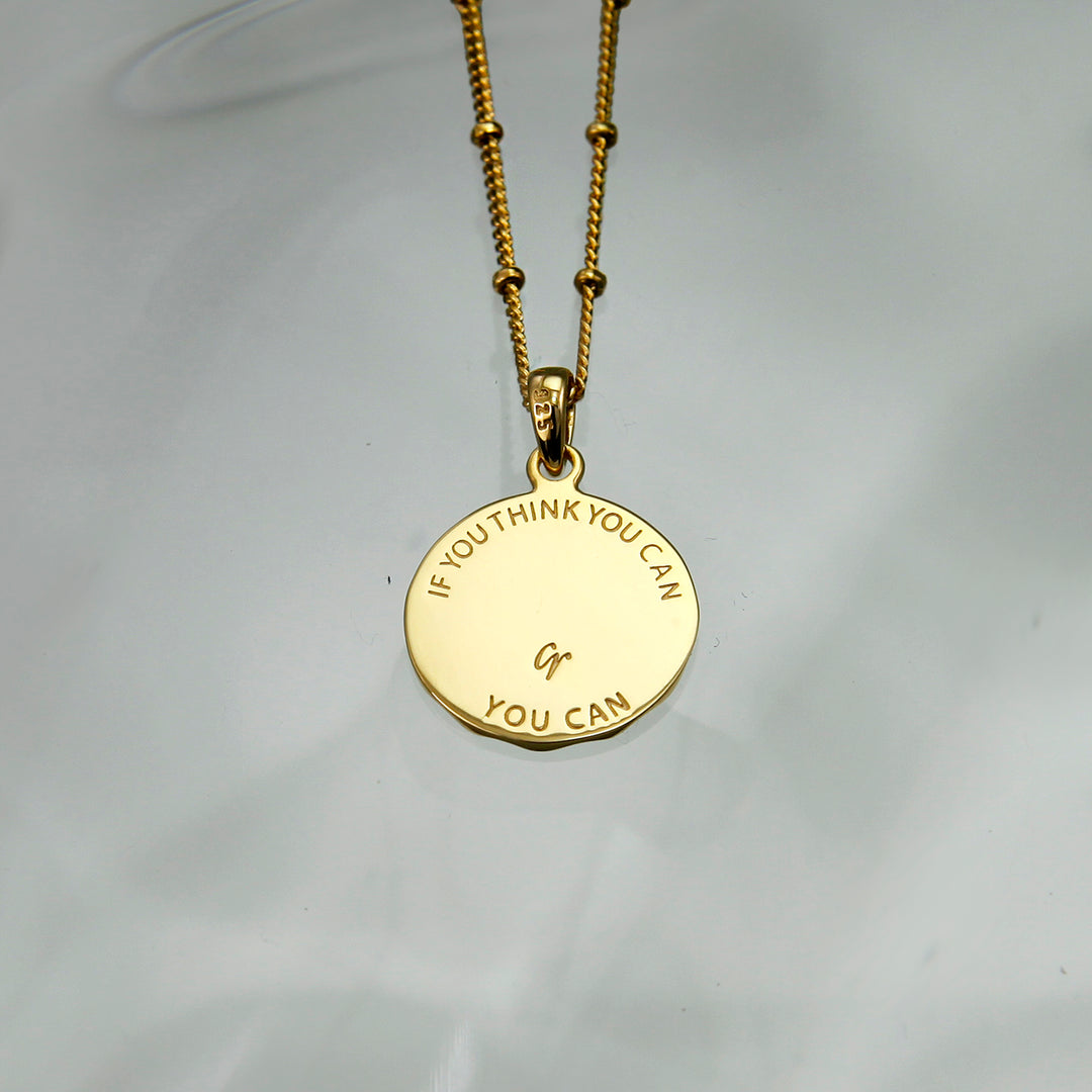 Reverse silver of a lucky charm horseshoe pendant with an engraved message on the back