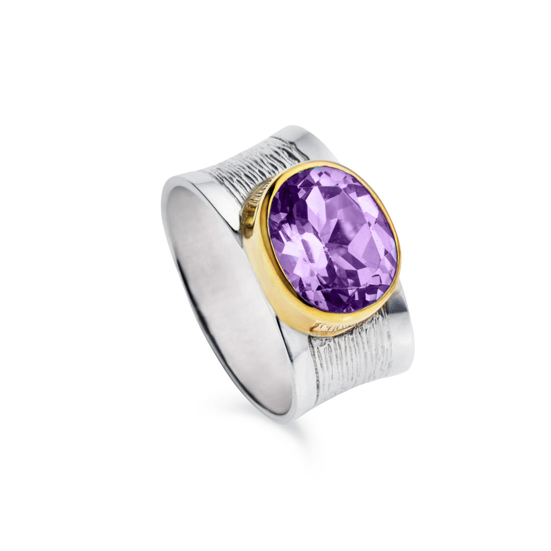 Ring with a purple gemstone and gold accents on a white background