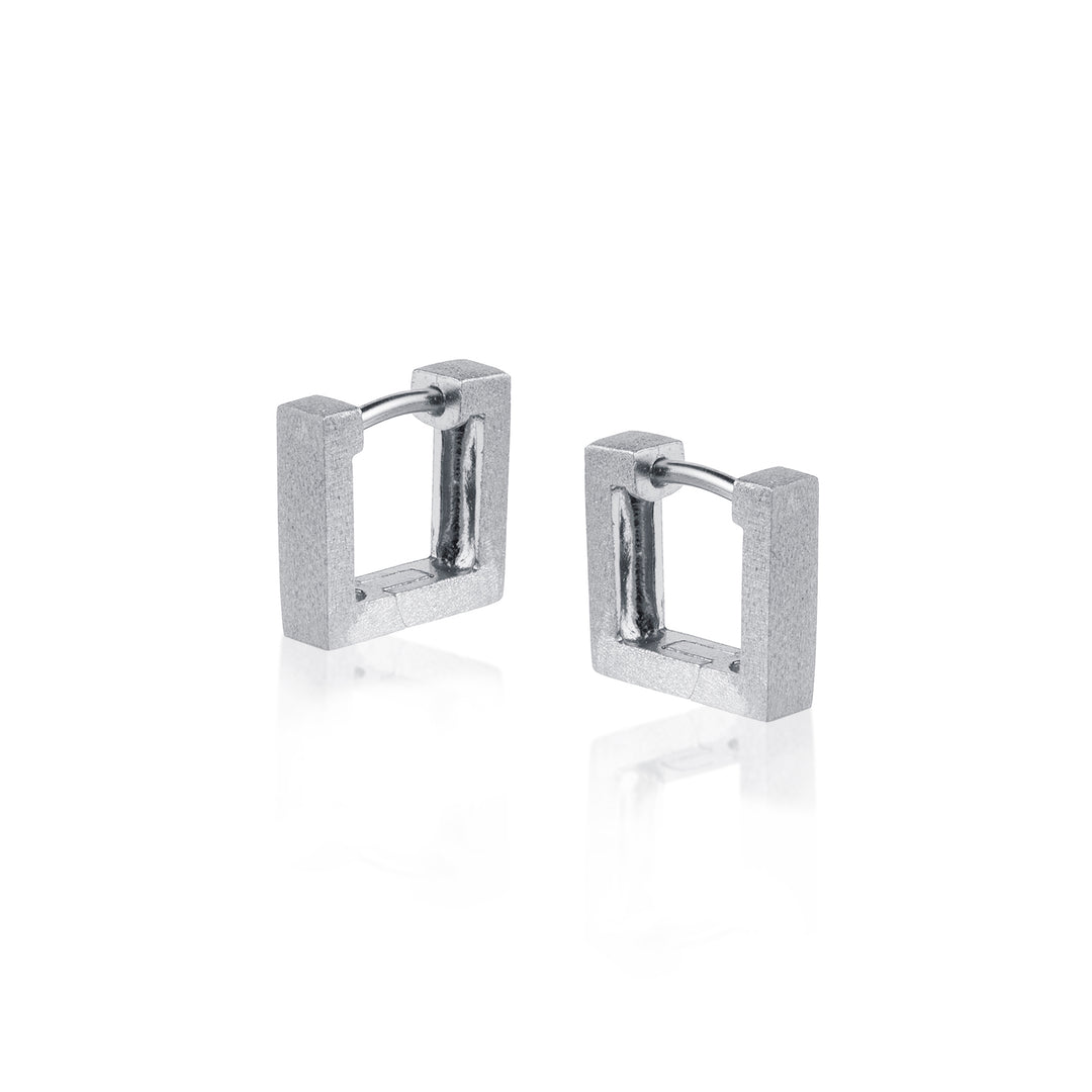 Pair of silver square huggie hoop earrings on a white background