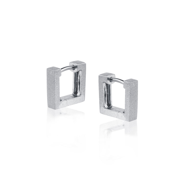 Pair of silver square huggie hoop earrings on a white background
