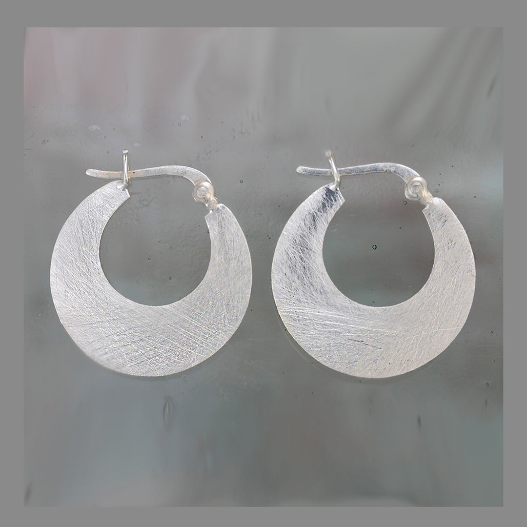 Silver hoop snap-post earrings on a gray background