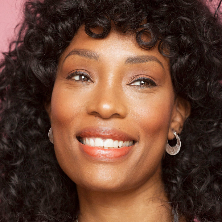 Close-up of a woman wearing flat silver hoop earrings