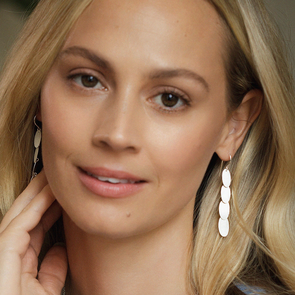 Close-up of a woman wearing silver cascading dangle earrings
