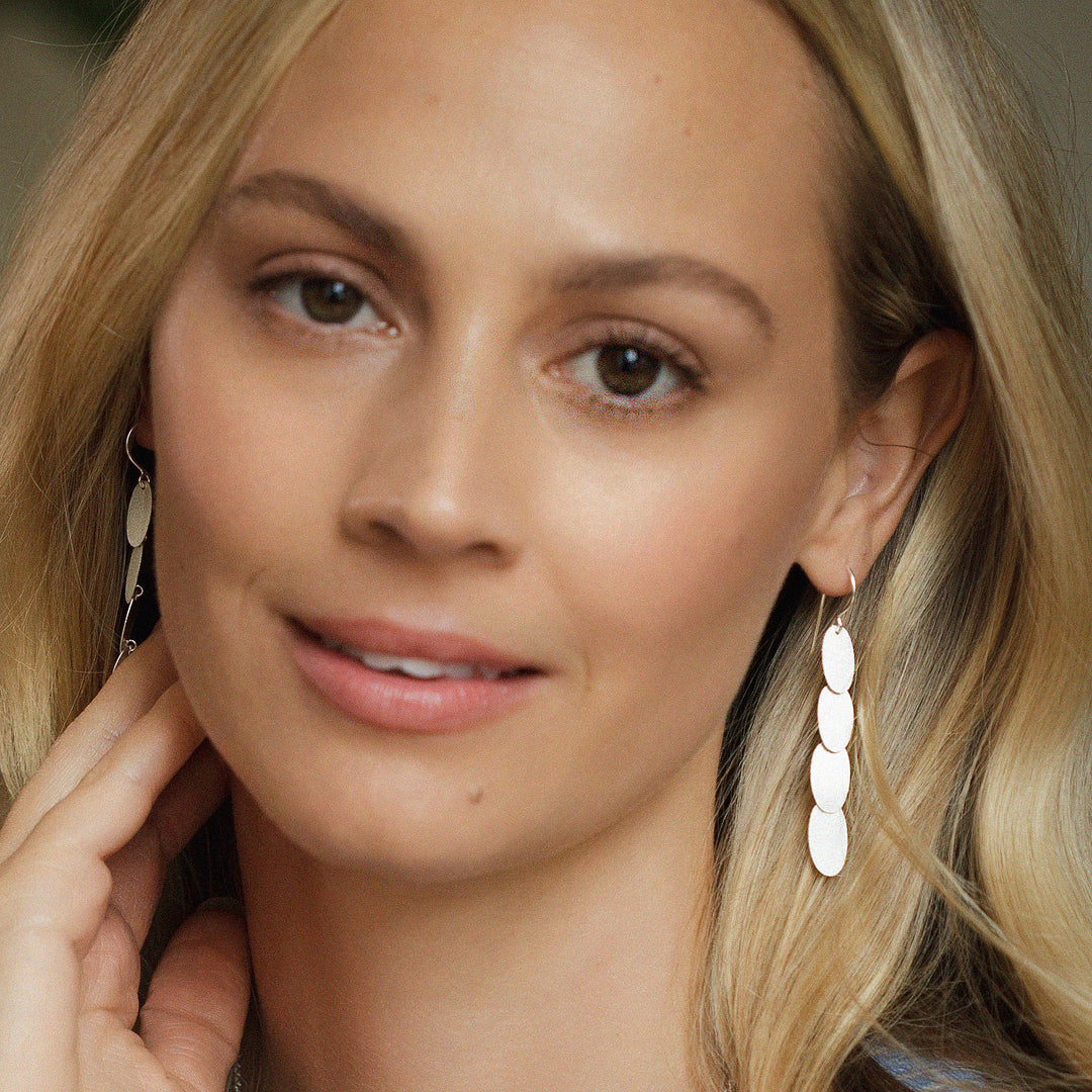 Close-up of a woman wearing silver cascading dangle earrings