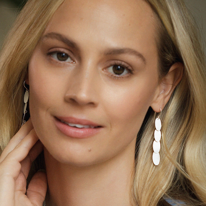 Close-up of a woman wearing silver cascading dangle earrings