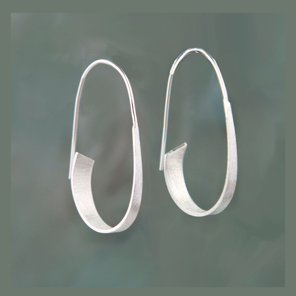 Pair of silver threader hoop earrings on a dark gray background