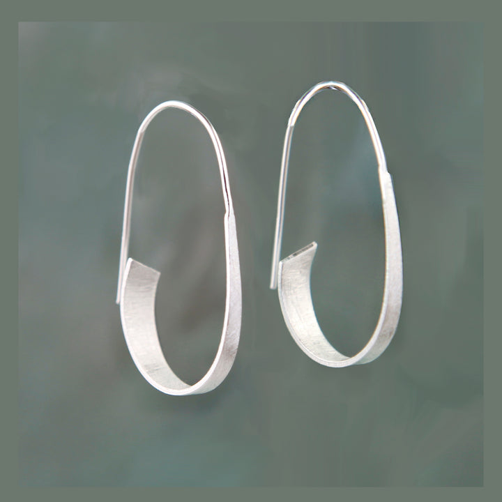 Pair of silver threader hoop earrings on a dark gray background