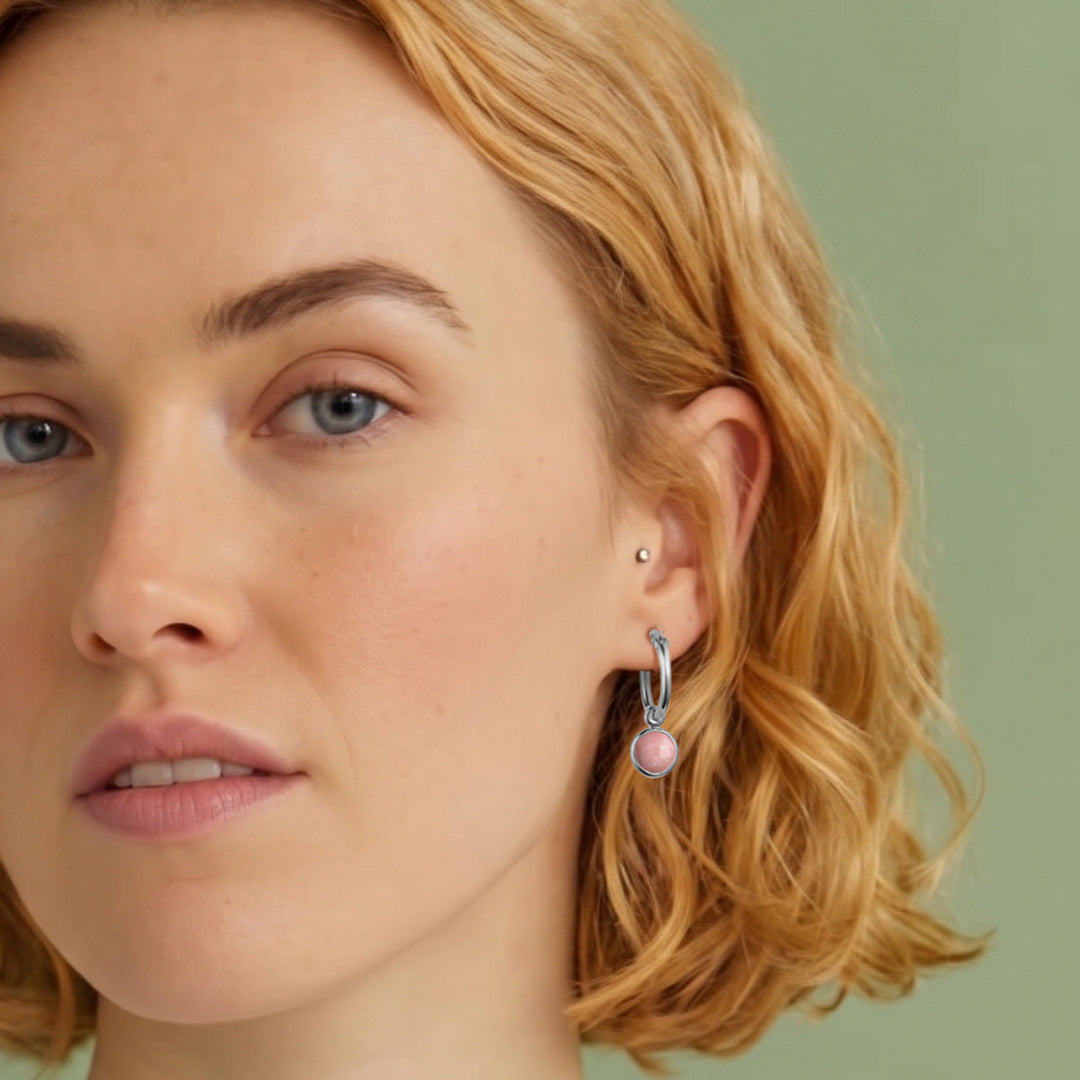 Close-up  of woman wearing pink opal gemstone huggie hoop earrings in sterling silver with snap post closure