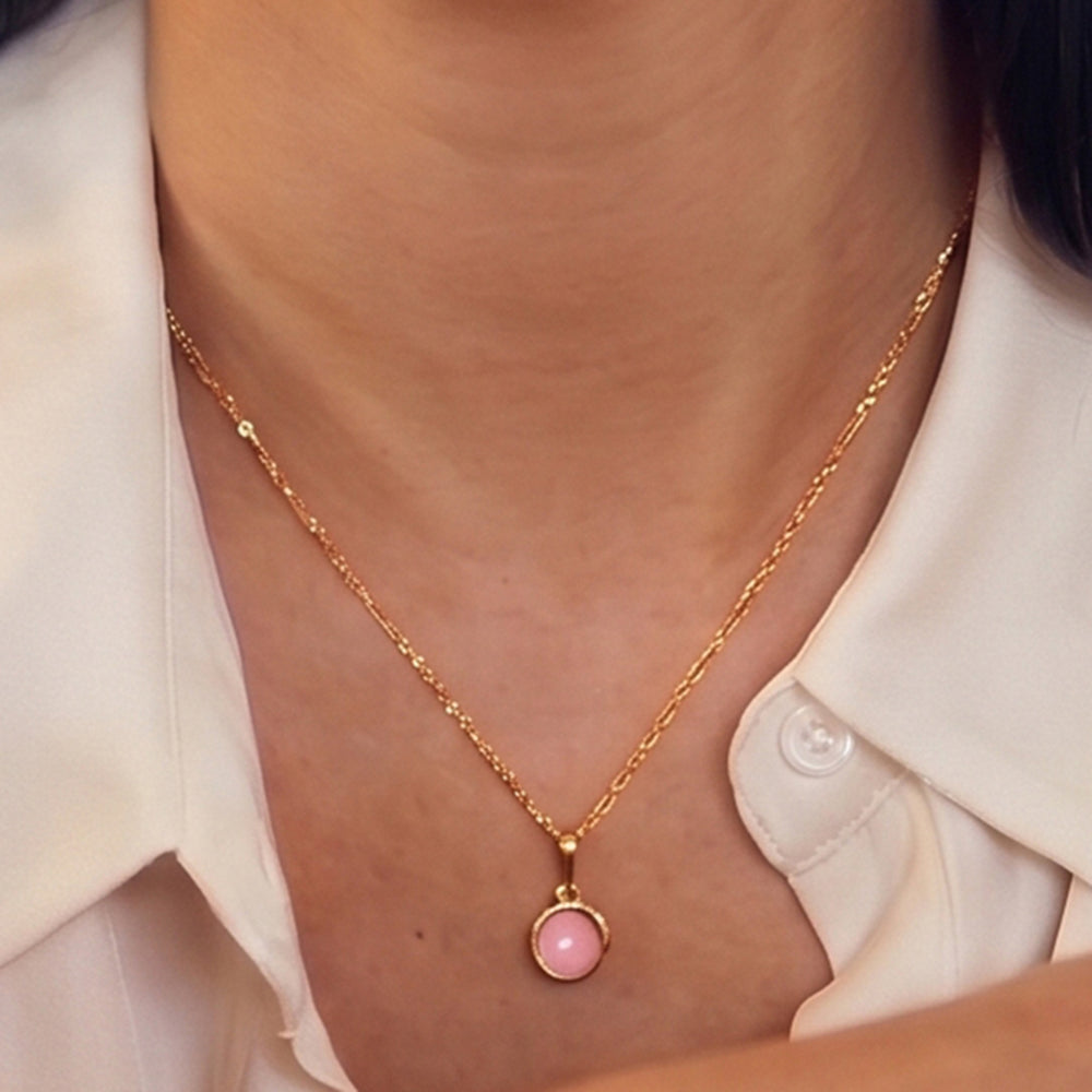 Close-up of woman wearing a pink opal pendant necklace in 18ct gold vermeil