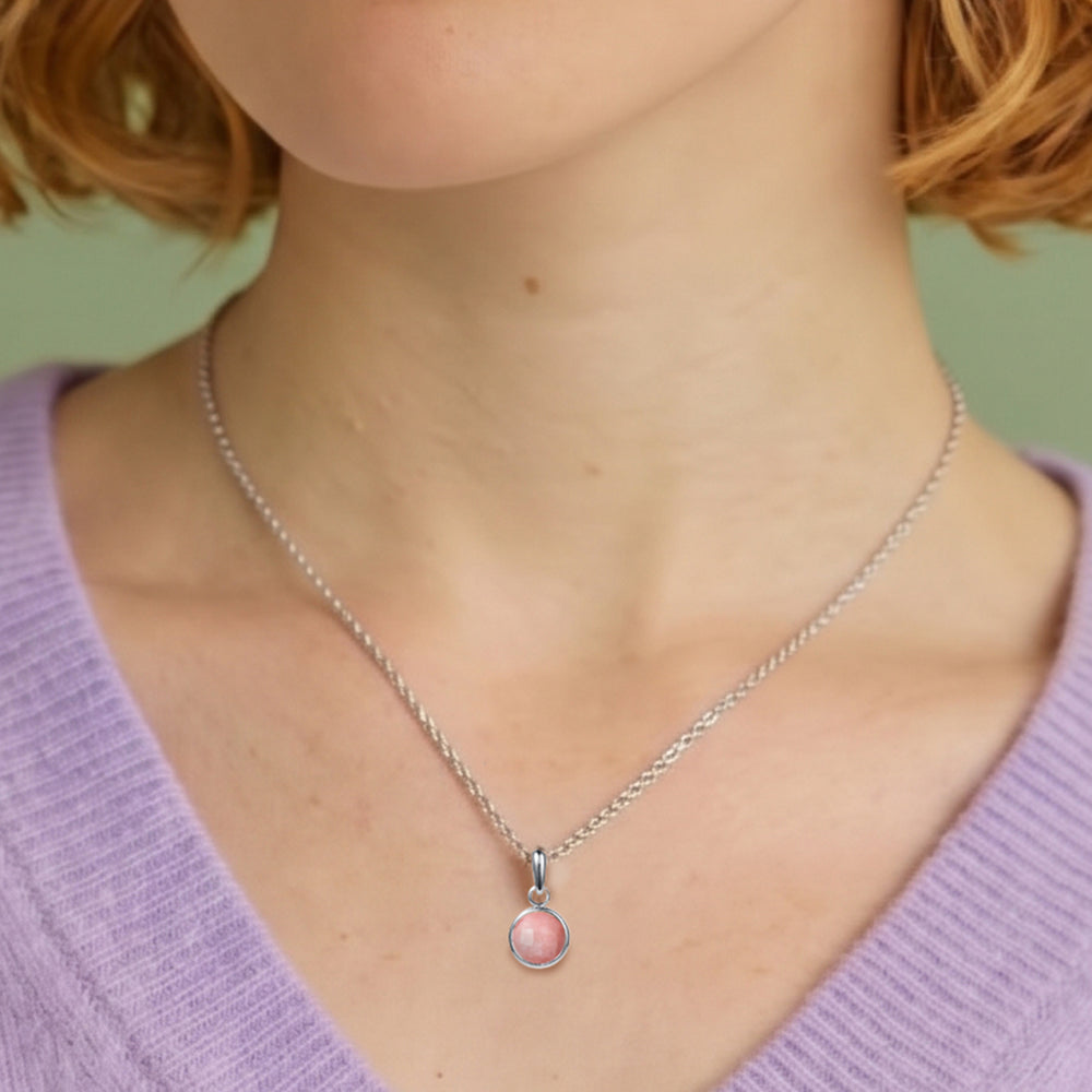 Close-up of woman wearing a pink opal gemstone pendant in sterling silver