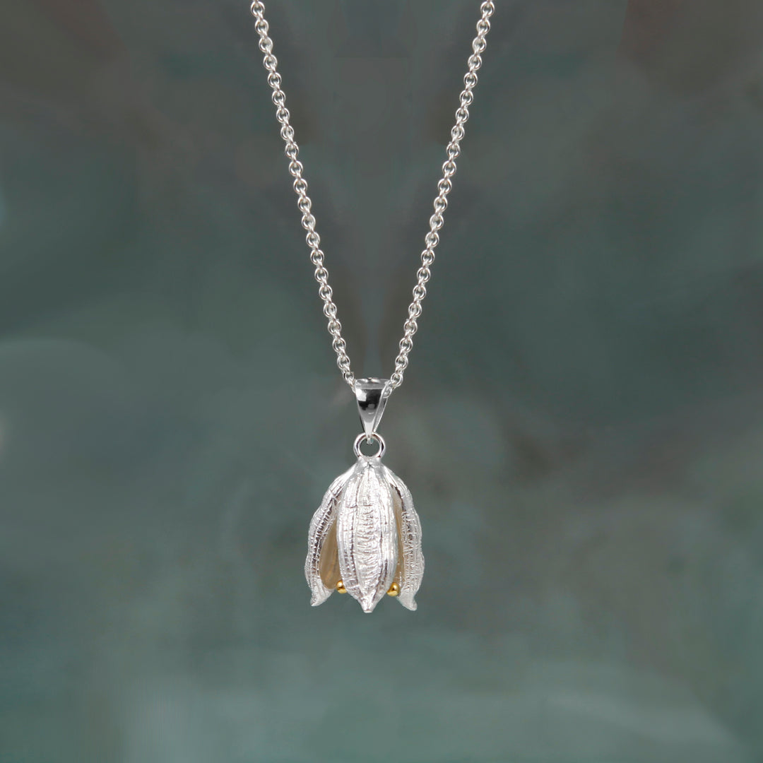 Silver flower pod design necklace with details on a gray background