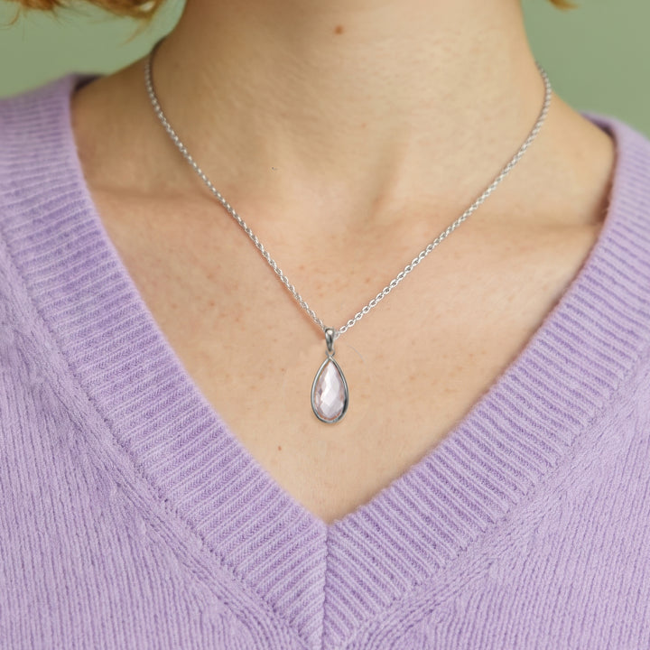 Close-up of woman wearing a rose quartz pear drop earring and necklace set with sterling silver